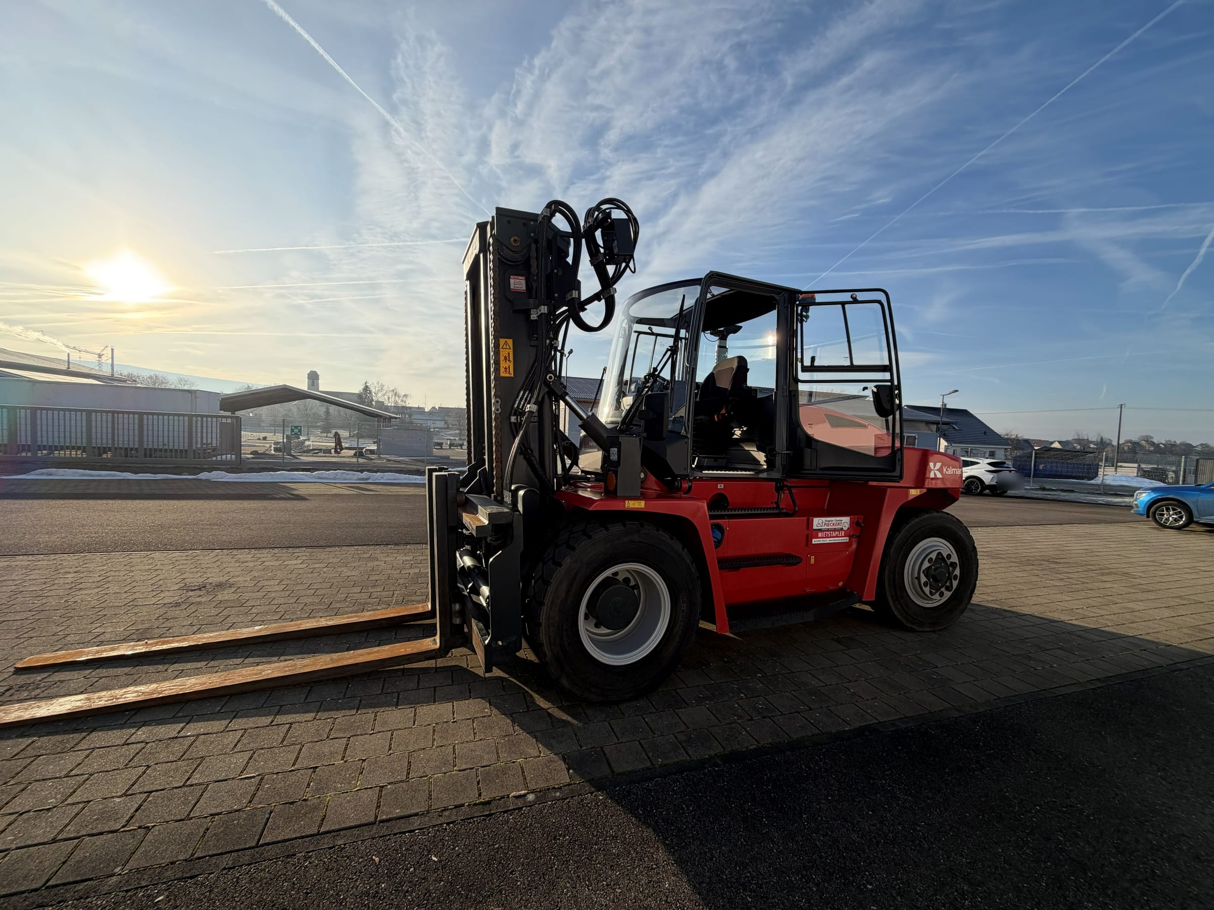 Schwerlaststapler auf einem Werksgelände bei Sonnenaufgang, bereit für die Verladung
